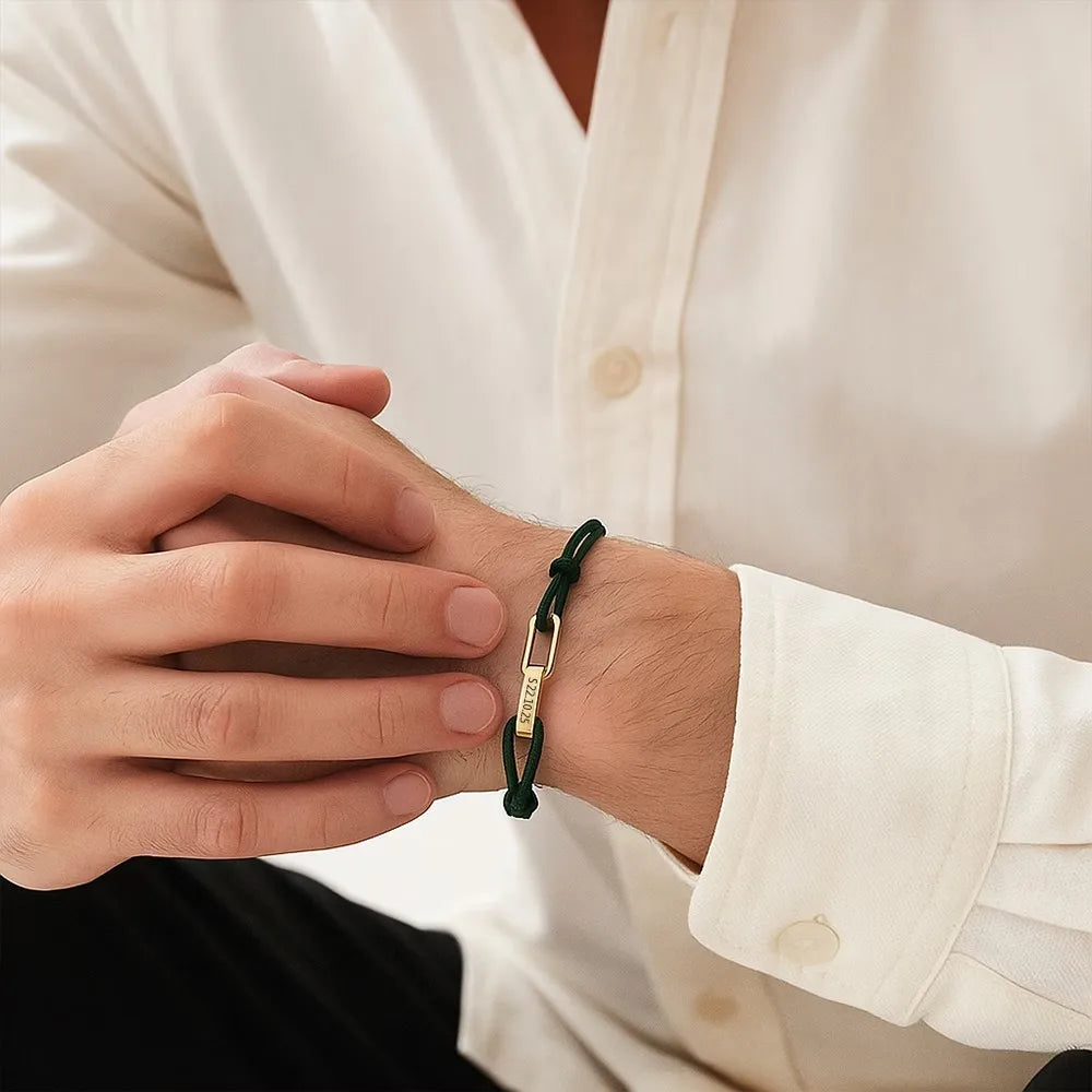 Man met een groene koppelarmband onder de manchet van een wit overhemd